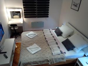 a bedroom with a bed with white sheets and pillows at Dučić Apartment in Trebinje
