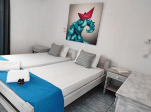 a room with two beds and a painting on the wall at Isalos Paros in Naousa +40 photos