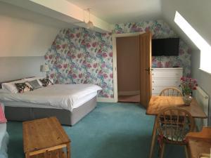 RattlesdenにあるDragonfly Cottage, Rattlesdenのベッドルーム1室(ベッド1台、テーブル、椅子付)