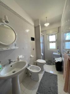 bagno bianco con lavandino e servizi igienici di Villa Belvedere a Trappeto