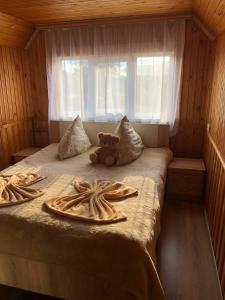a teddy bear sitting on a bed in a room at HOUSE Mold in Lazeshchyna
