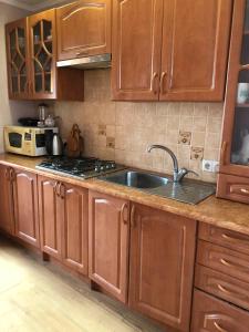 a kitchen with wooden cabinets and a sink at HOUSE Mold in Lazeshchyna
