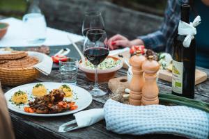 Organic Tourist Farm Pri Plajerju في ترينتا: طاولة مع أطباق من الطعام وزجاجة من النبيذ