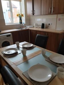 a kitchen with a table with white plates on it at Flat 1. Cleethorpes apts in Cleethorpes