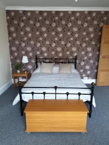 a bedroom with a bed with a brown wall at Flat 1. Cleethorpes apts in Cleethorpes