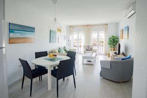 a living room with a white table and chairs at Apartamento con Vistas al mar in Conil de la Frontera