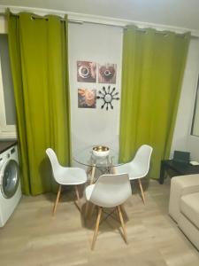 sala de estar con cortinas verdes, mesa y sillas en Centro Goya Apartamento en Madrid