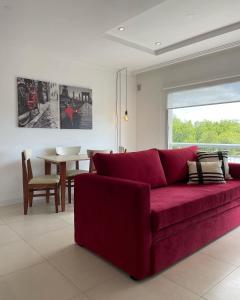 a living room with a red couch and a table at Administración MAIPU 3B DEPTO PREMIUM in Tandil