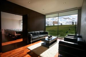 a living room with a long table and a large glass window at Finca Prats Hotel Golf & Spa in Lleida