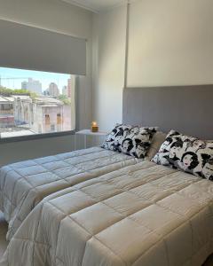 a bedroom with a large bed with a large window at Administración MAIPU 3B DEPTO PREMIUM in Tandil