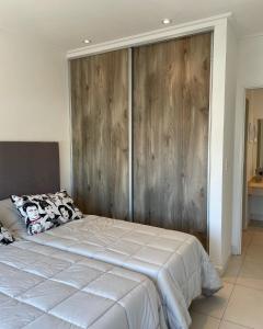 a bedroom with a bed with a wooden wall at Administración MAIPU 3B DEPTO PREMIUM in Tandil +4 photos