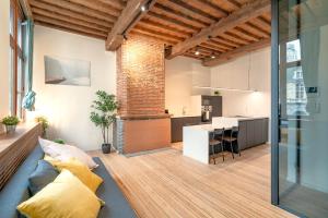 uma sala de estar em plano aberto com um sofá e uma cozinha em The Hendrik Square Residence em Antuérpia