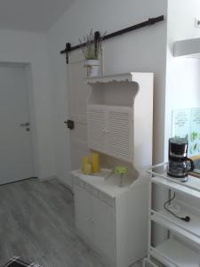 a white kitchen with a counter and a shelf at Das kleine Lavendelhaus in Kahl am Main
