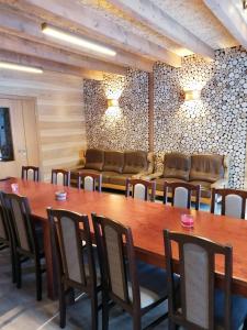 jadalnia z dużym drewnianym stołem i krzesłami w obiekcie Viesu nams Liepas w mieście Baltais Dukstgals