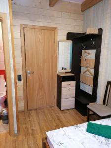 a room with a door and a dresser with a mirror at Viesu nams Liepas in Baltais Dukstgals