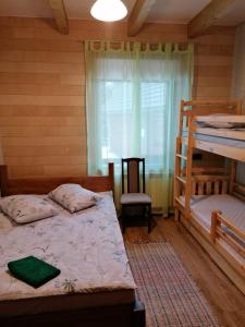 a bedroom with two bunk beds and a window at Viesu nams Liepas in Baltais Dukstgals