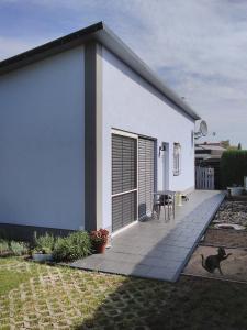 a small white house with a dog sitting on a patio at Das kleine Lavendelhaus in Kahl am Main