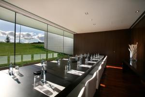 a large dining room with a long table with white chairs at Finca Prats Hotel Golf & Spa in Lleida