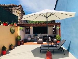 un patio con una mesa y una sombrilla en La Galayca, en El Barcenal