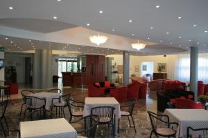 a restaurant with tables and chairs and red chairs at Hotel Risorgimento in Chianciano Terme