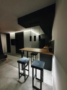 a kitchen with a table and stools in a room at Apartamenty HashtagWilda in Poznań
