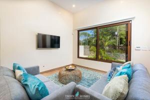 ein Wohnzimmer mit einem Sofa und einem TV in der Unterkunft Casa Coralis - NEW modern house with private pool in Potrero
