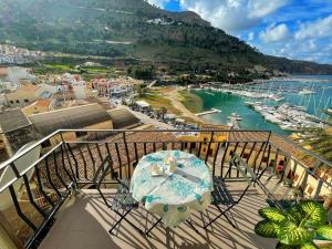 een balkon met een tafel en uitzicht op een haven bij Suite Altamarea "Sea View Studios" in Castellammare del Golfo