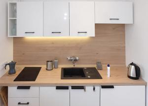 a kitchen with white cabinets and a sink at A spacious apartment for holidays and weekends in Ełk +11 photos