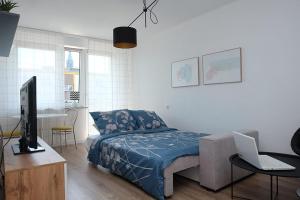 a bedroom with a bed and a desk with a laptop at A spacious apartment for holidays and weekends in Ełk