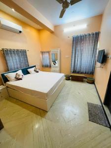 una camera da letto con un grande letto bianco e due finestre di Vedsa Haveli a Udaipur