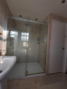 a shower with a glass door next to a sink at Loft in Bungay in Bungay
