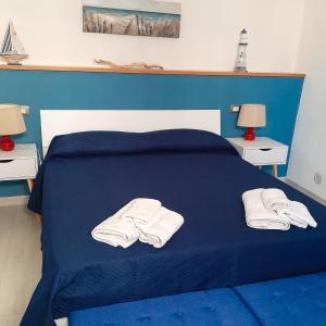 un letto blu con due asciugamani bianchi sopra di BREZZA MARINA 33 - Castellammare del Golfo a Castellammare del Golfo