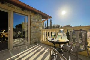 un patio con tavolo e sedie sul balcone. di Da Ilaria primo piano di villa con piscina e parcheggio a Grosseto