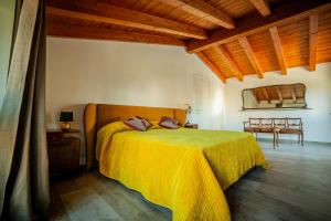 a bedroom with a bed with a yellow blanket at Da Ilaria primo piano di villa con piscina e parcheggio in Grosseto