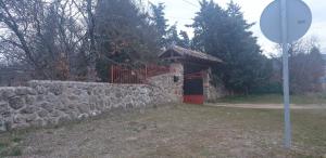 un mur en pierre avec un portail et une clôture en pierre dans l'établissement Exclusiva Casa y Finca Privada ITOS, à Pelayos del Arroyo