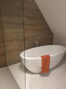 a white bath tub in a bathroom with a wall at Côté Grange in Tournai