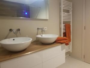 a bathroom with two white sinks on a counter at Côté Grange in Tournai