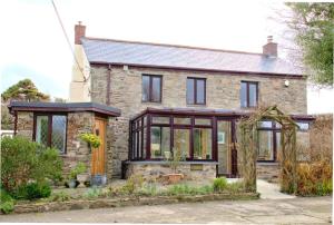 an extension to a stone house with black windows at Mellowvean in St. Agnes