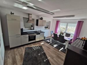 a kitchen and living room with a table and chairs at Ferienwohnung Hensel am Herzmannser See in Waltenhofen