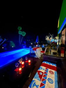 a swimming pool at night with a table and candles at Colorful Pool Villa, Chiang Rai, Thailand in Chiang Rai