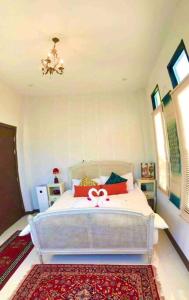 ein Schlafzimmer mit einem weißen Bett mit einer rosa Schleife in der Unterkunft Colorful Pool Villa, Chiang Rai, Thailand in Chiang Rai