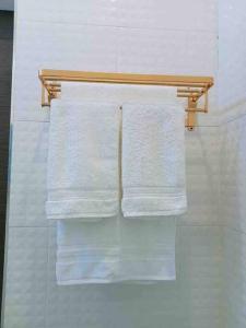 - un ensemble de serviettes suspendues sur un portant dans la salle de bains dans l'établissement Colorful Pool Villa, Chiang Rai, Thailand, à Chiang Rai