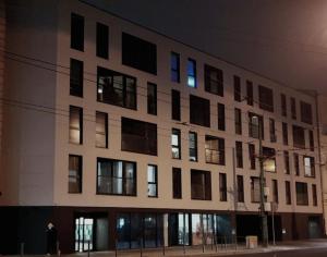 a large white building with many windows at night at Apartamenty HashtagWilda in Poznań