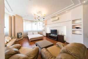 een woonkamer met een bank en een televisie bij Роскошная 3к квартира 135м2 на набережной. Минская in Kiev