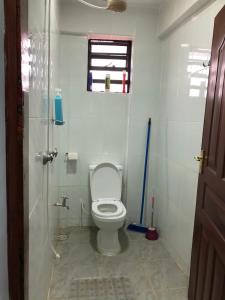 a bathroom with a toilet and a glass shower at Maluhia Halelaa- A9 in Naivasha
