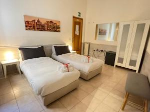 een woonkamer met 2 bedden en een bank bij Roman Holidays Rooms Otranto in Rome