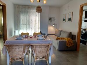 sala de estar con mesa con sillas y sofá en Apartamento acogedor en playa de Moncofa, en Moncófar