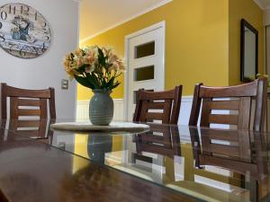 a dining room with a table with a vase with flowers at Mirador Villarrica Apartment in Villarrica