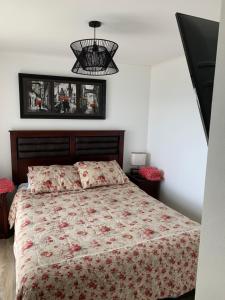 1 dormitorio con 1 cama grande con colcha de flores en Mirador Villarrica Apartment, en Villarrica