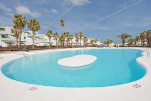 une grande piscine avec une chaise au milieu dans l'établissement Lanzahost Villa Ona, à Costa Teguise